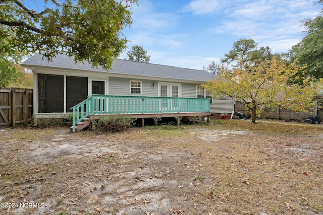 rear view of house featuring a sunroom and a deck