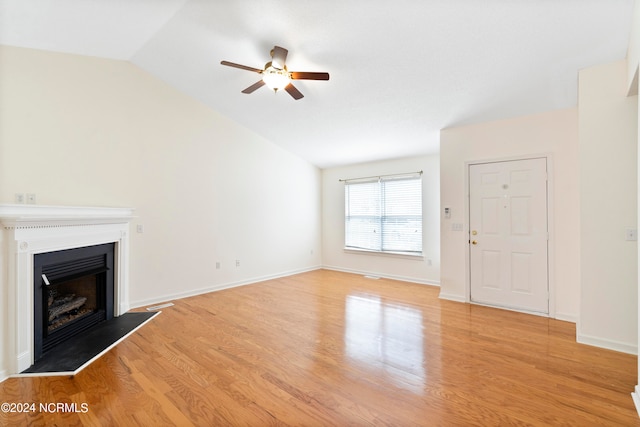 unfurnished living room featuring lofted ceiling, light wood-type flooring, and ceiling fan