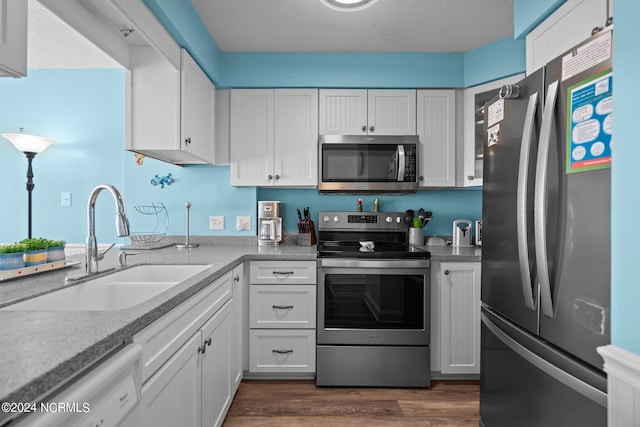 kitchen with white cabinetry, sink, stainless steel appliances, and dark hardwood / wood-style flooring