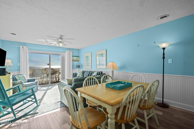 503 Pelican Ct Unit 503, Kure Beach, NC 28449 - dining space with a wainscoted wall, wood finished floors, a textured ceiling, and a ceiling fan
