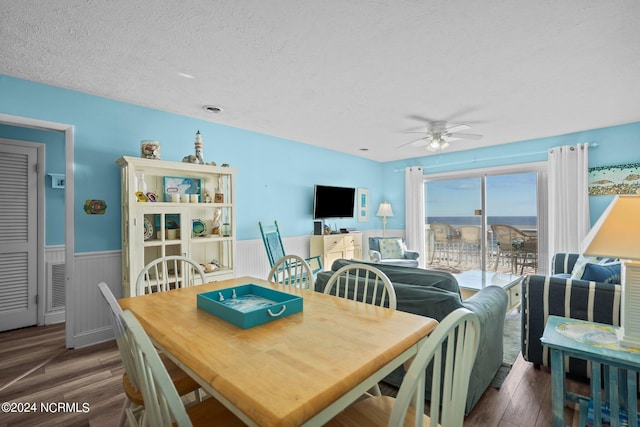 dining room with dark wood-type flooring, ceiling fan, and a textured ceiling