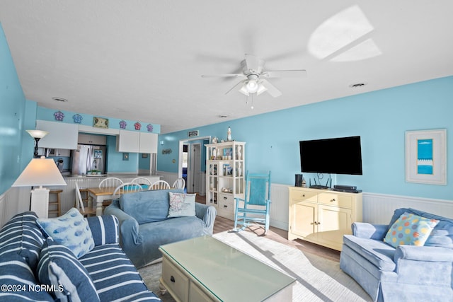 living room with light hardwood / wood-style floors and ceiling fan