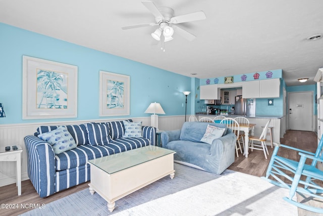 living room featuring ceiling fan and hardwood / wood-style flooring