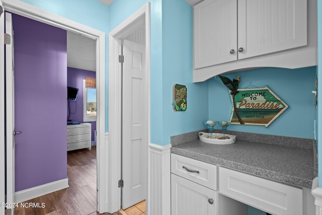 interior space featuring white cabinets and hardwood / wood-style floors