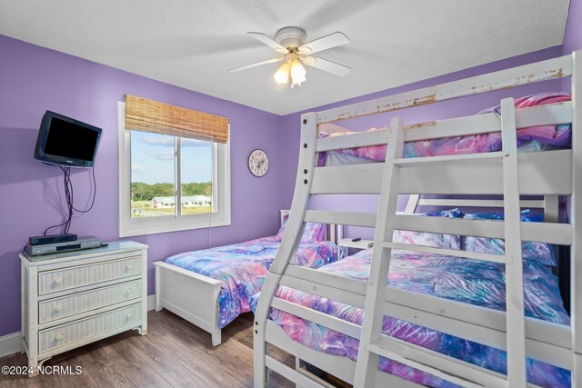 503 Pelican Ct Unit 503, Kure Beach, NC 28449 - bedroom with wood finished floors, a textured ceiling, a ceiling fan, and baseboards