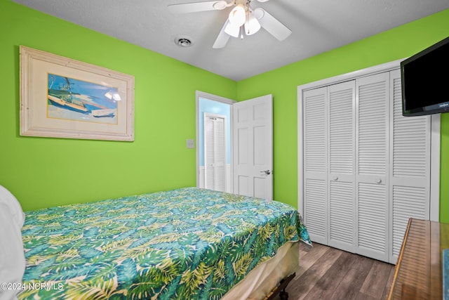 bedroom with ceiling fan, dark wood-type flooring, a closet, and a textured ceiling