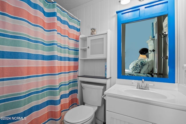 bathroom with walk in shower, vanity, toilet, and a textured ceiling