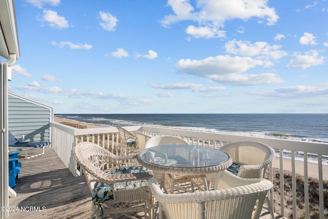 balcony featuring a water view and a beach view