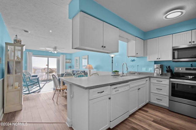 kitchen with a textured ceiling, appliances with stainless steel finishes, sink, and white cabinetry