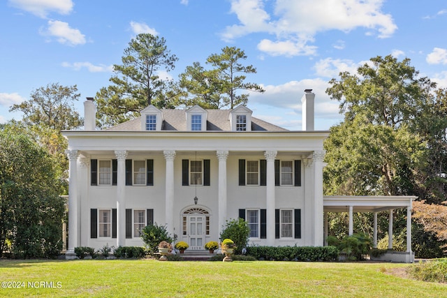 neoclassical / greek revival house featuring a front yard