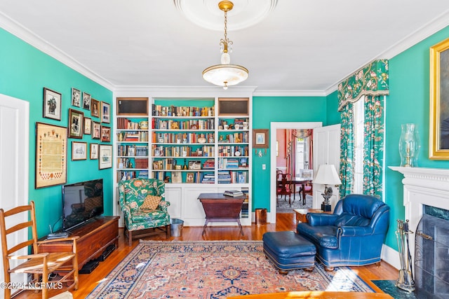 sitting room with hardwood / wood-style flooring and ornamental molding