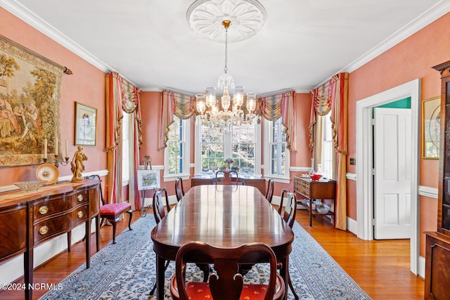 dining room featuring light hardwood / wood-style flooring, ornamental molding, and a chandelier