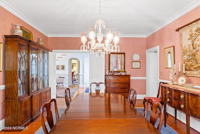 dining area featuring ornamental molding, an inviting chandelier, and hardwood / wood-style floors