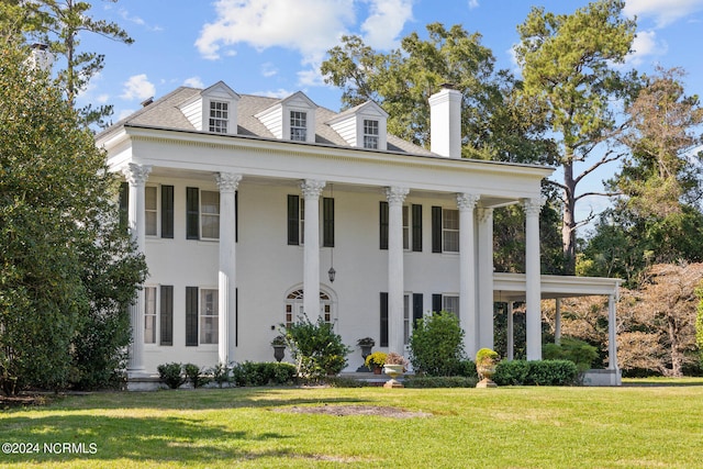 greek revival inspired property featuring a front lawn