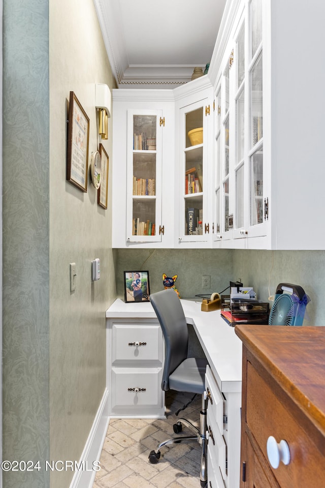 office with built in desk and ornamental molding