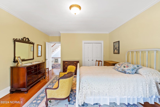 bedroom featuring ornamental molding, hardwood / wood-style floors, and a closet