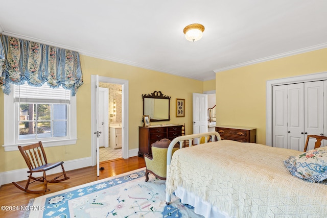 bedroom featuring hardwood / wood-style floors, ensuite bathroom, crown molding, and a closet