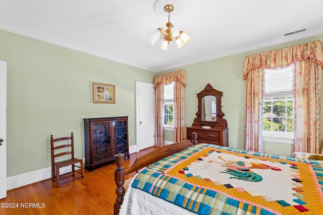 bedroom featuring crown molding, hardwood / wood-style flooring, and an inviting chandelier