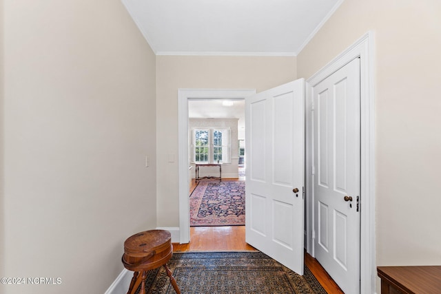 hallway with ornamental molding and dark hardwood / wood-style flooring