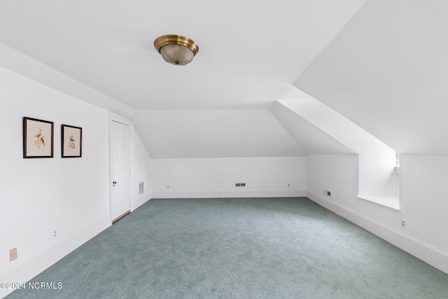 additional living space featuring vaulted ceiling and carpet floors