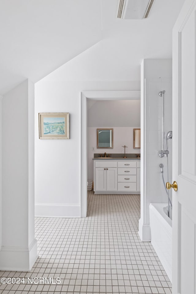 bathroom featuring vanity, plus walk in shower, lofted ceiling, and tile patterned floors