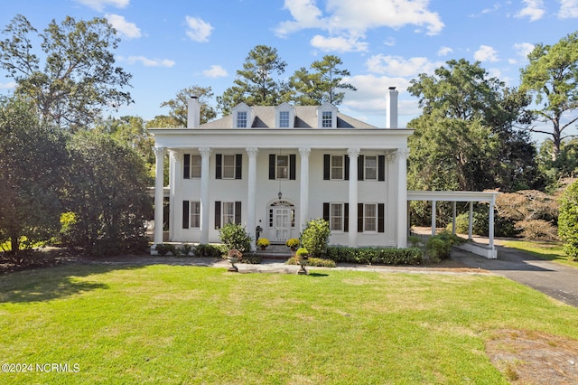 neoclassical / greek revival house with a carport and a front lawn