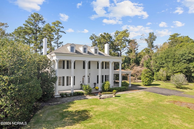 neoclassical / greek revival house featuring a front yard