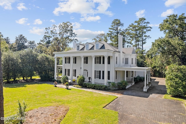 greek revival house with a porch and a front lawn