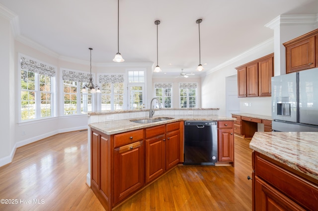 kitchen featuring sink, hanging light fixtures, black dishwasher, an island with sink, and light hardwood / wood-style floors