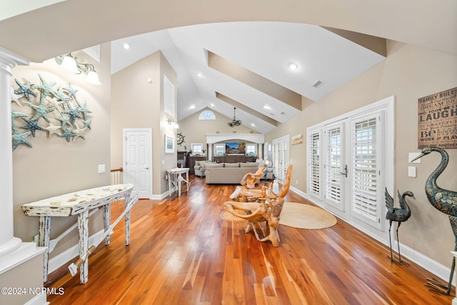 living room featuring french doors, high vaulted ceiling, wood-type flooring, and decorative columns