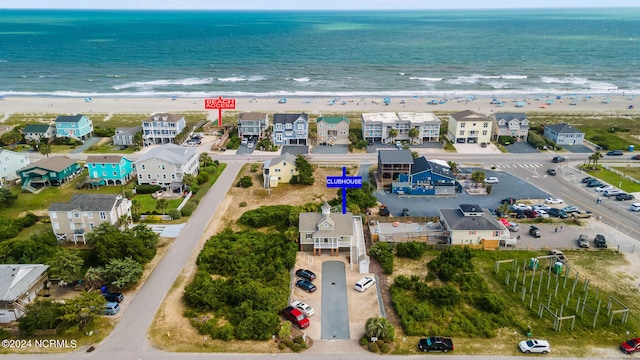 birds eye view of property featuring a water view and a beach view