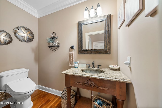 bathroom with toilet, crown molding, hardwood / wood-style floors, and vanity