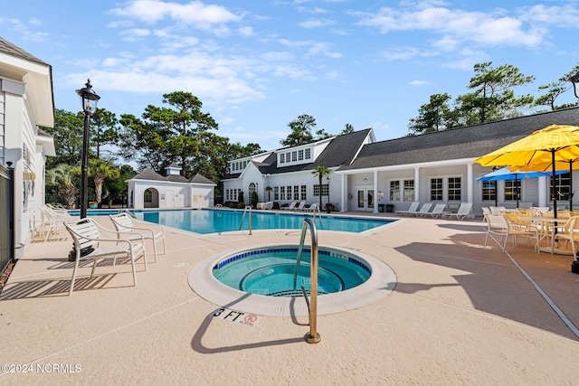 view of swimming pool with a hot tub and a patio area