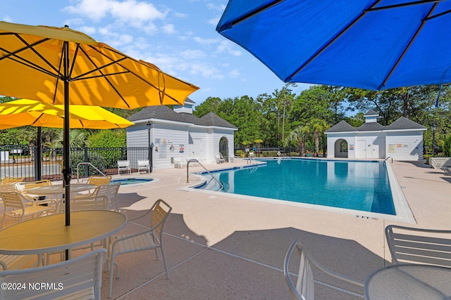 view of pool with a patio and a community hot tub