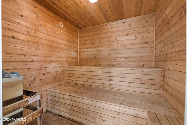 view of sauna / steam room featuring wooden ceiling and wooden walls