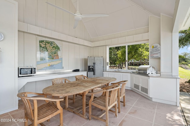 dining room with lofted ceiling, sink, light tile patterned floors, and ceiling fan