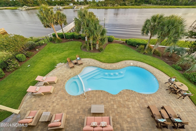 view of swimming pool featuring a water view, a patio area, a lawn, and a jacuzzi