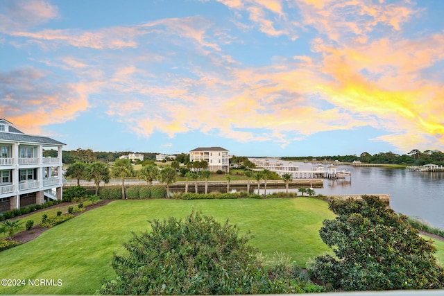 exterior space featuring a lawn, a water view, and a balcony