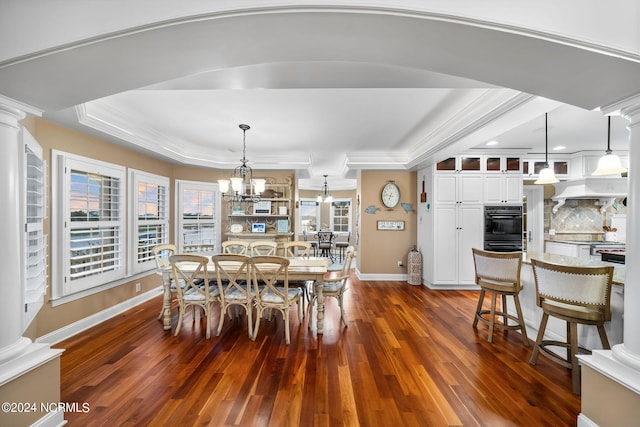 dining room featuring an inviting chandelier, ornamental molding, dark wood-type flooring, and ornate columns