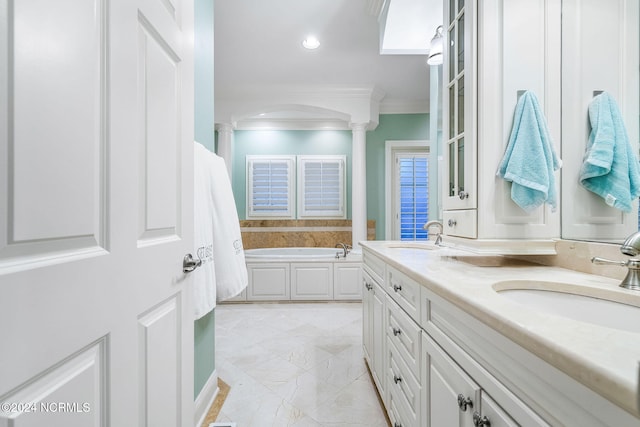 bathroom with a bathtub, crown molding, decorative columns, and vanity