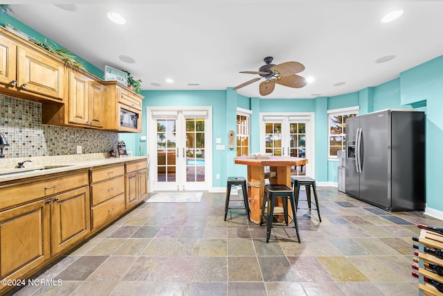 kitchen with french doors, decorative backsplash, stainless steel fridge with ice dispenser, and sink