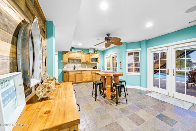 interior space with french doors, ceiling fan, and sink