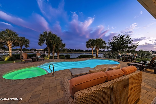 pool at dusk featuring a patio