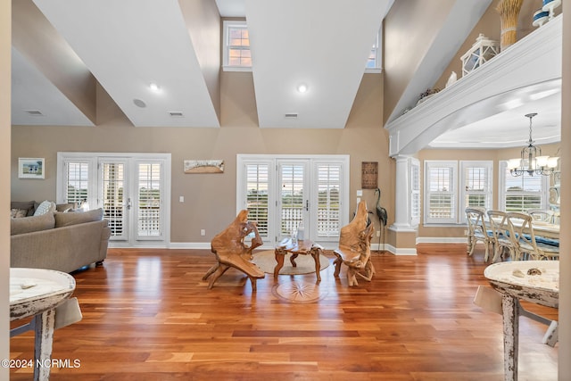 interior space with light hardwood / wood-style flooring, ornate columns, and a healthy amount of sunlight