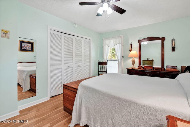 bedroom with ceiling fan, a closet, and light hardwood / wood-style flooring