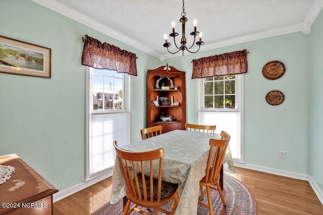 dining room featuring a notable chandelier, light hardwood / wood-style flooring, and ornamental molding