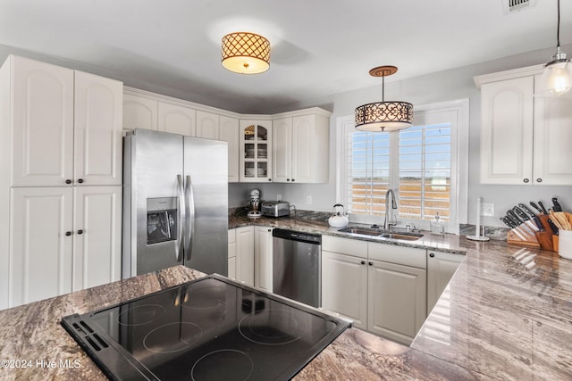 kitchen with white appliances, white cabinetry, hanging light fixtures, and sink