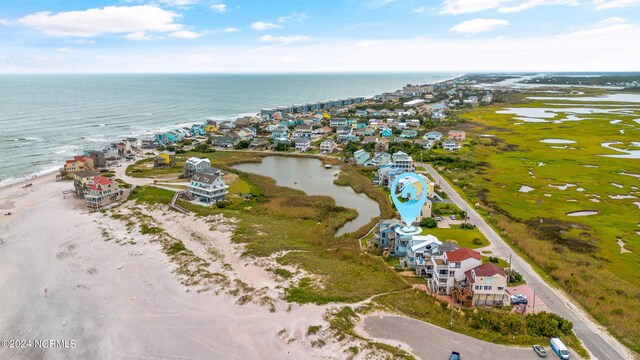 birds eye view of property featuring a water view and a beach view