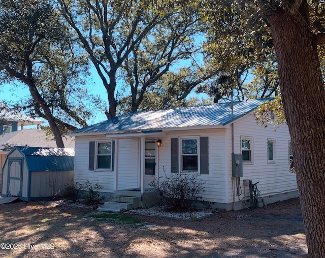 view of front of home featuring a storage unit, an outdoor structure, crawl space, and metal roof