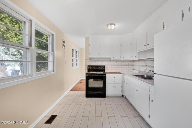 kitchen with white cabinets, light wood-type flooring, black electric range, sink, and white refrigerator